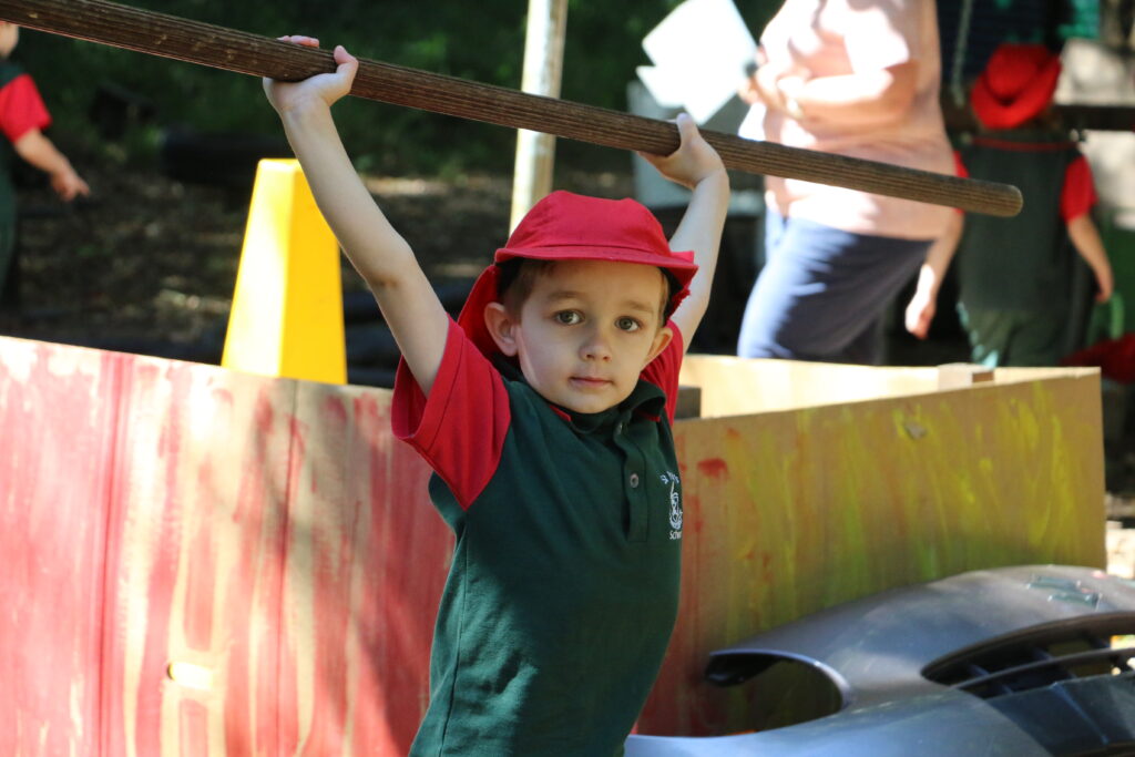 St Paul's School Pre-Prep student lifting pole above head