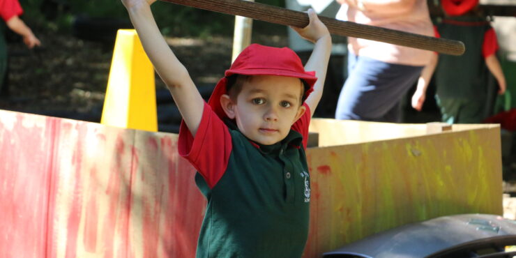 St Paul's School Pre-Prep student lifting pole above head